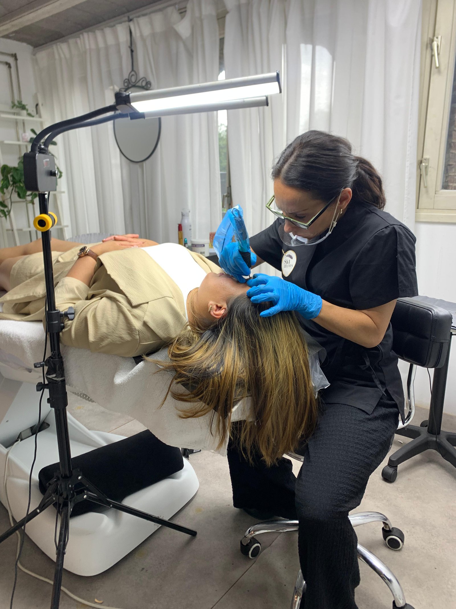 Ilaria tattooing a client's brows in the studio